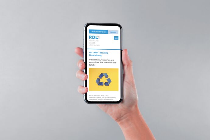 Hand hält ein smartphone auf dem eine Recycling Webseite geöffnet ist